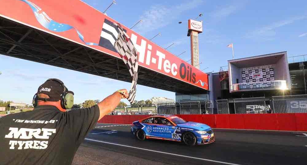 man waving a flag at the finish line at bathurst